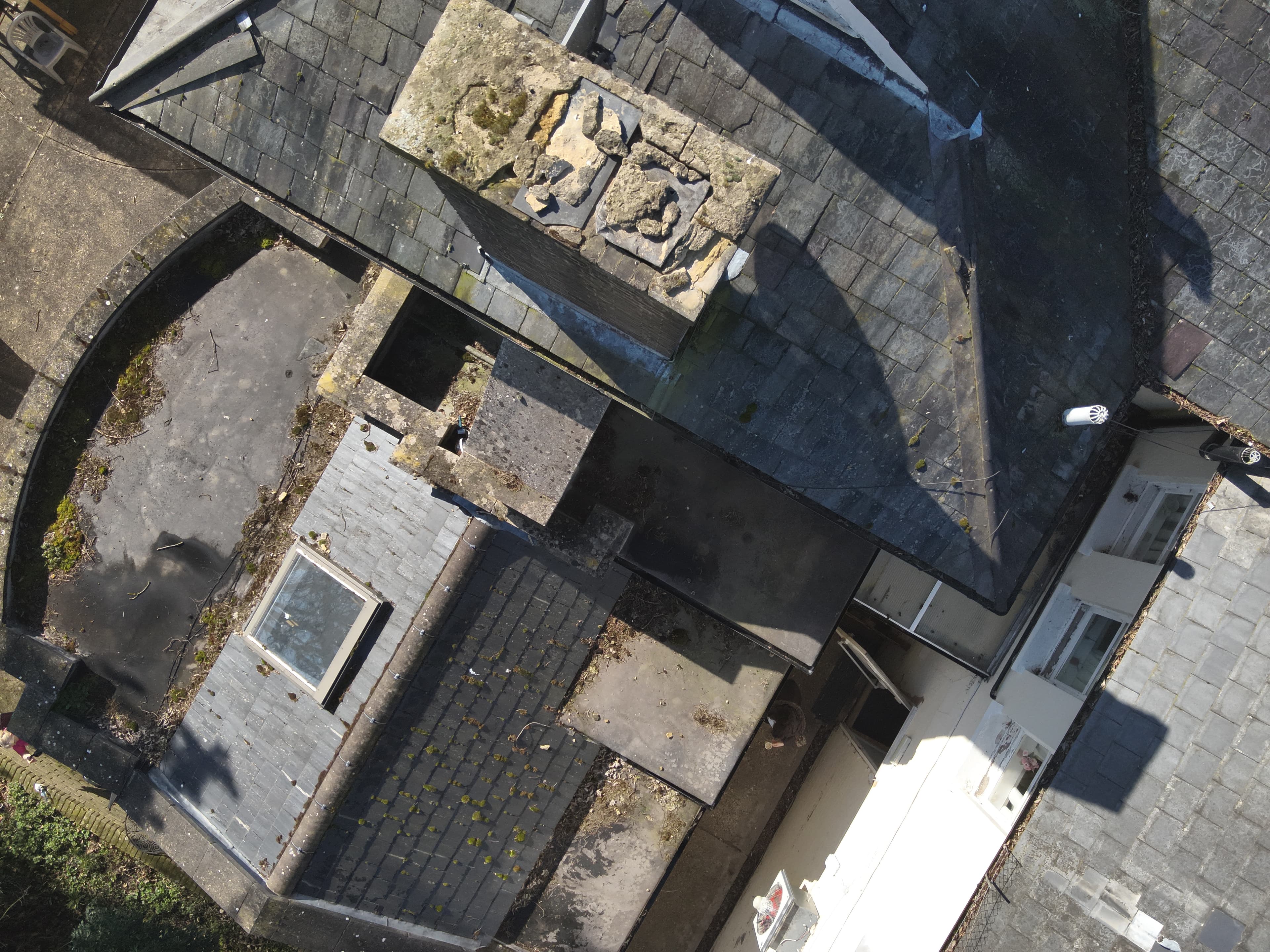 Aerial view of heritage care home roof showing slate, chimneys, and period stonework